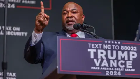 Getty Images Mark Robinson, the Lt Governor of North Carolina and candidate for Governor, delivers a speech on stage before a Trump campaign event in August.