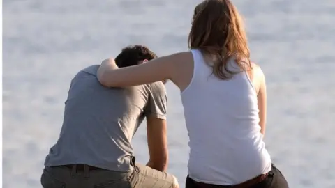 Getty Images Woman comforts depressed man