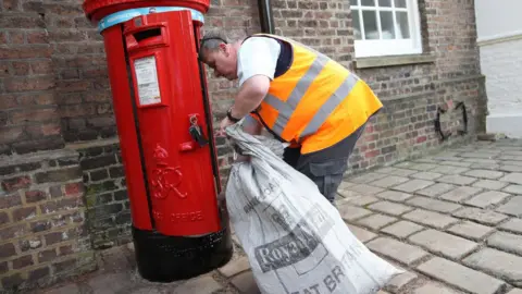 Getty Images Postman empties letter box