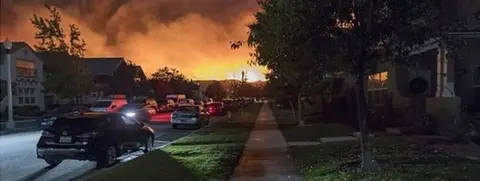 Image depicting an explosion on the horizon of a suburban landscape