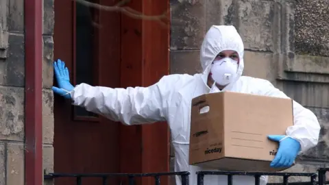 PA Media File image of a police forensics officer entering a building