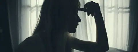 Getty Images Generic image of a young woman, silhouetted, with head on her hand