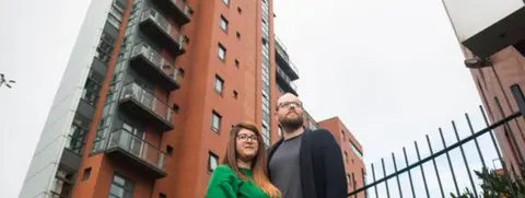Dani Leitch and Mark Hughson outside their Manchester flat
