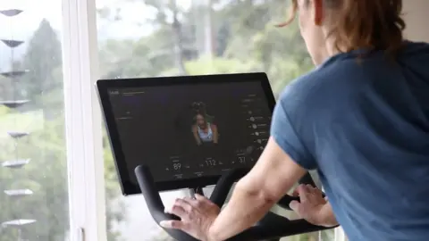 Getty Images a woman with a Peloton bike