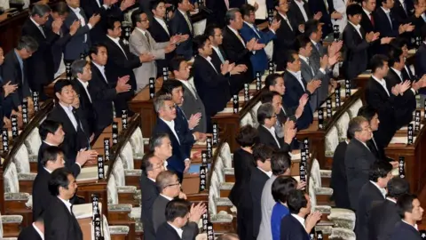 TORU YAMANAKA Members of Japan's lower house of parliament stand up to support a bill during the plenary session in Tokyo on June 2, 2017.