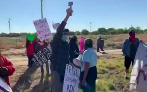 Bea Redfeather Dozens of Shiprock residents protest against cannabis farms holding signs reading: Resist marijuana farms