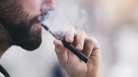 Getty Images Man smoking an e-cigarette