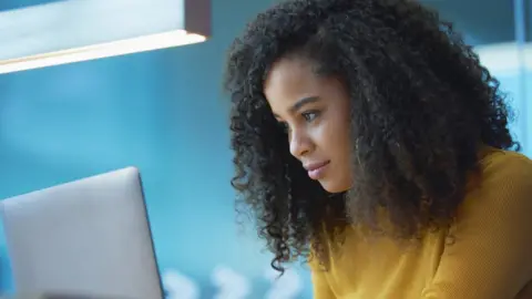 Getty Images Woman looking at laptop in office