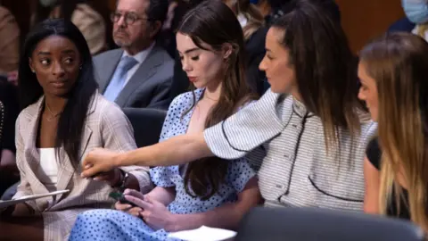 Getty Images US gymnasts (L-R) Simone Biles, McKayla Maroney, Aly Raisman and Maggie Nichols arrive to testify during a Senate Judiciary hearing about the Inspector General's report on the FBI handling of the Larry Nassar investigation of sexual abuse of Olympic gymnasts, on Capitol Hill, September 15, 2021, in Washington, DC.