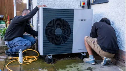 Getty Images Technicians from Solaris Energy carry out the first annual service and clean on a Vaillant Arotherm plus 7kw air source heat pump that was installed into a 1930s built house on the 16th of September 2022 in Folkestone, United Kingdom.