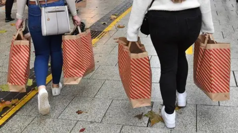 Ben Birchall/PA Wire Two women shopping