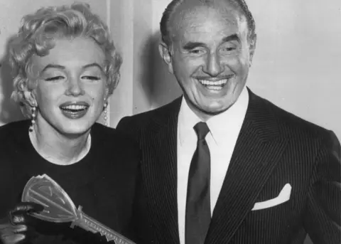 Getty Images Marilyn Monroe being presented with the symbolic Warner Bros. key by Jack Warner, the studio's president in 1956