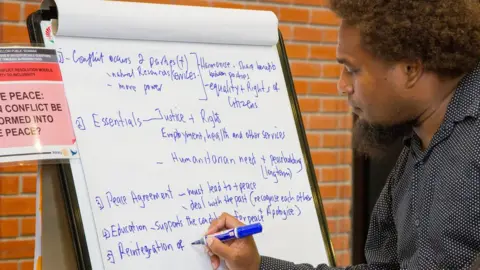 Rotarypeacechula Kemuel Laeta writing notes about peace and conflict