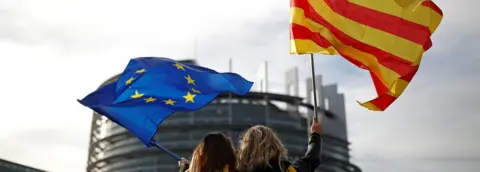 Reuters Two women wave EU and Catalan flags outside the European Parliament
