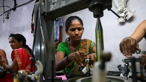 Getty Images Women employees work on diamond polishing machines at a factory in Surat.
