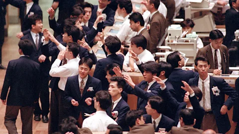 Getty Images Dealers work on the floor of the Tokyo Stock Exchange in March 1992 (Credit: Getty Images)