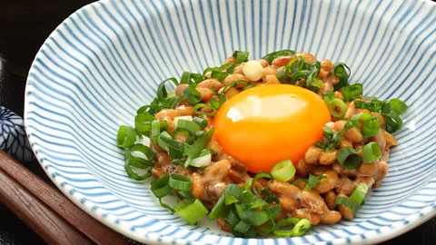 Hungryworks/Getty Images Nattō is a fermented soy-based food that’s often served with spring onion and raw egg (Credit: Hungryworks/Getty Images)