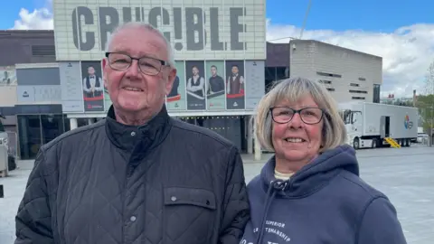 Simon Thake/BBC A man and women stand together outside the Crucible Theatre
