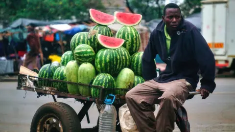 AFP A vendor selling watermelons in Zimbabwe - November 2017