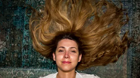 BBC Shaparak lies on a rug with her hair out.