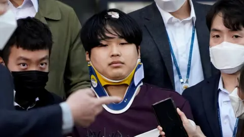 Reuters Cho Ju-bin outside the police station, wearing a neck brace
