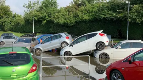 PA Media cars piled up after flooding