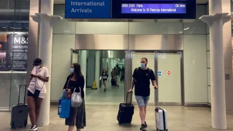 PA Media Travellers arriving from the Eurostar at St Pancras International railway station as they try to get back from France on Friday