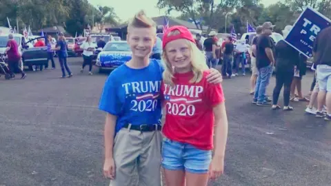 Clare Krenzelok Elihu and Ezra stand in a parking lot