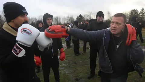 Getty Images Members of the Alpha Men Assemble work out with boxing gloves and pads for fitness for team building on January 8, 2022 in Brownhills, England.