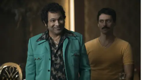 Netflix A scene out of the Netflix series showing two men in a meeting.