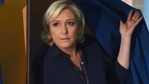 AFP National Front (FN) leader Marine Le Pen walks out of a voting booth in Henin-Beaumont in northern France on June 11, 2017