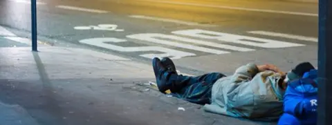 Getty Images Man asleep on a Paris street