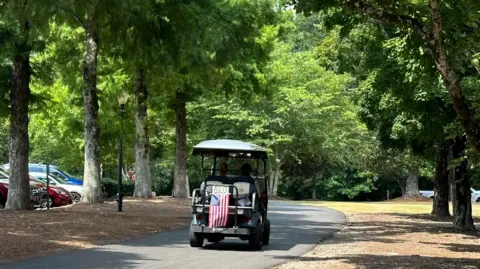 Brandon Drenon/BBC A golf cart drives through Peachtree City, Georgia 
