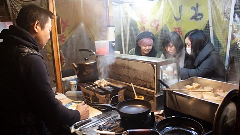 Edd Gent Eiji Abe prepares food at his yatai Maruyoshi. He argues that yatai are informal spaces that allow people to let down their guard with strangers (Credit: Edd Gent)