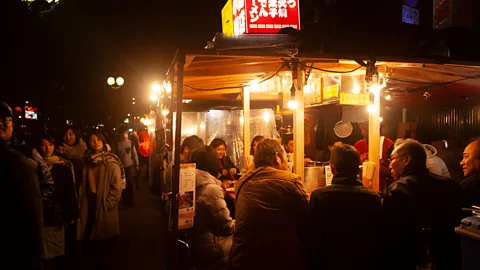 Edd Gent Punters peruse the many yatai found lining the canal in Fukuoka's city’s nightlife district of Nakasu (Credit: Edd Gent)