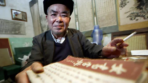 Frederic J Brown/Alamy Ironically, much of what we know about Nüshu is due to a man, Zhou Shuoyi, who tirelessly translated it and created the first dictionary in 2003 (Credit: Frederic J Brown/Alamy)