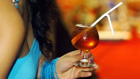 Getty Images A Sri Lankan woman holds a cocktail during a drinks competition in Colombo, 26 February 2017