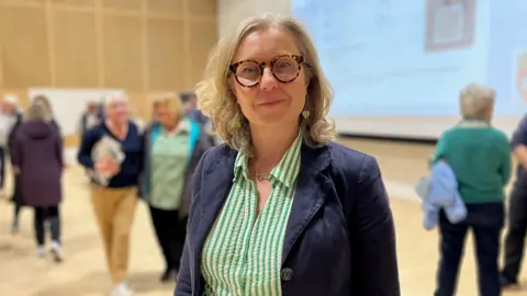 MSP Rachael Hamilton - a blonde-haired woman in glasses - with a blue jacket on and a green and white striped blouse underneath