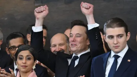 Getty Images Elon Musk holds his fists in the air during the inauguration of Donald Trump