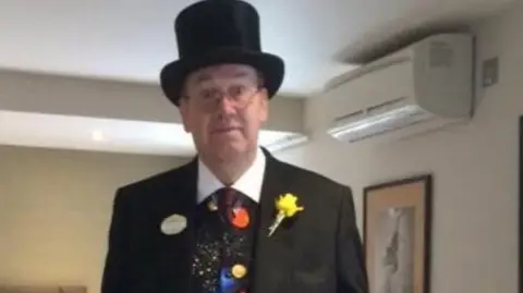Kevin Booth wearing a top hat, black jacket and a patterned waistcoat.