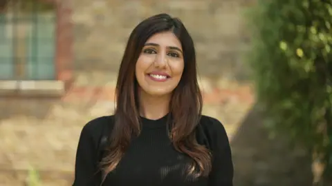 BBC Lovina Shenoy in a black dress. She has brown hair. 