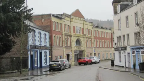 Jim Barton A different angle view of the Pavilion Cinema on a wet day in Galashiels with cars parked in front of it with its yellow and brick facade.