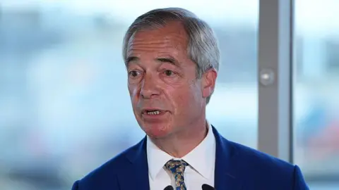 Getty Images Nigel Farage, a man with grey hair wearing a blue suit and patterned tie.